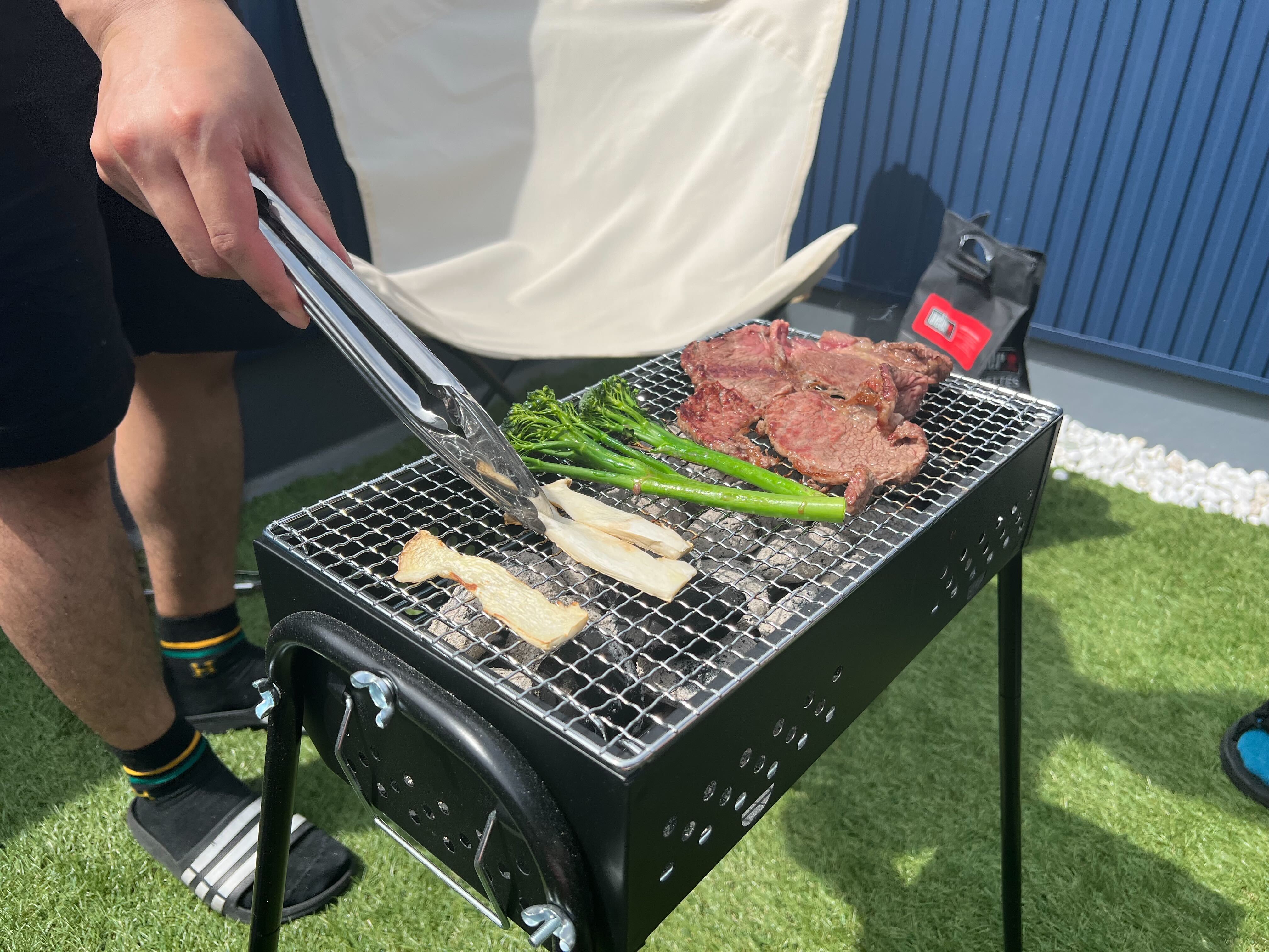 ベランダでコンロの上でお肉やキノコを焼いている様子