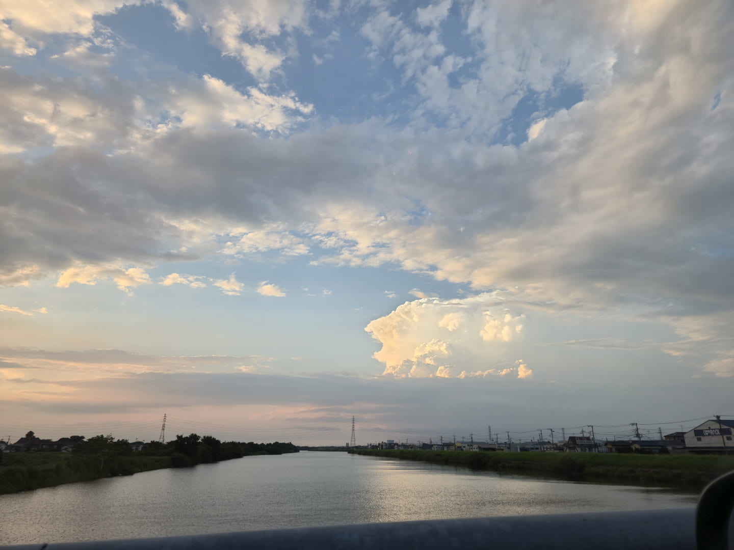 きれいな夕焼け空の下、大きな川が映っている。力強い雲と共に。