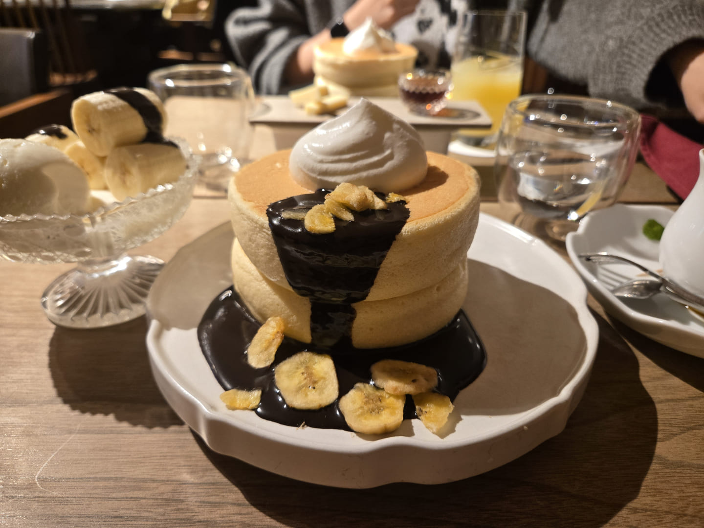 ふわっふわ 2枚重なった分厚いパンケーキにチョコシロップがかけられていて、その上に生クリーム。