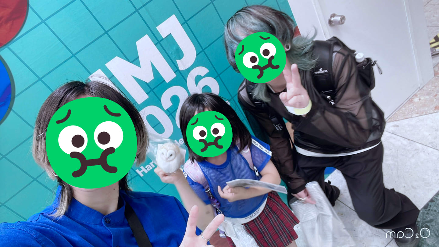 HMJ 2026 と書かれたパネルの前で両親と2人に挟まれた女の子の3人が写っている。